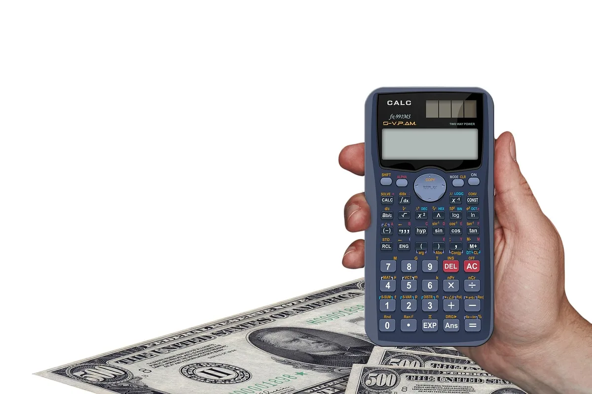 Documents de revenus et calculatrice sur une table, illustrant le calcul des aides