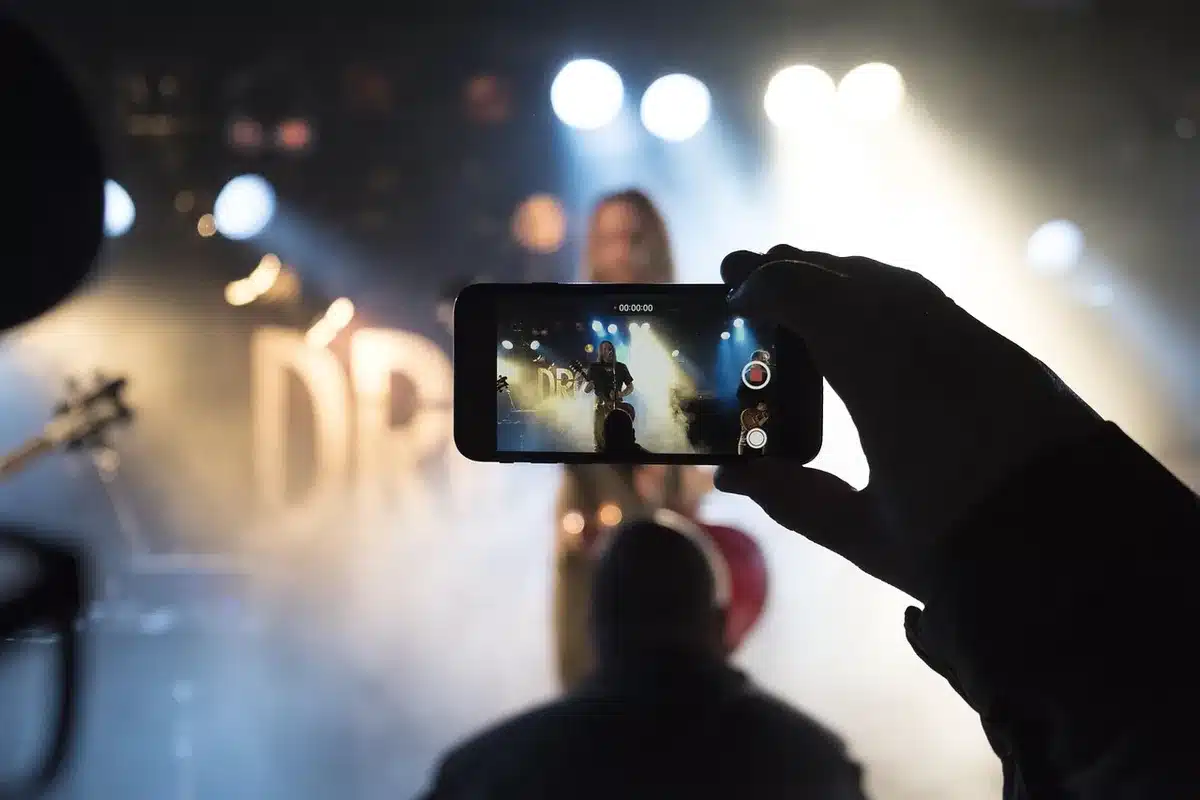 Mains anonymes comparant des documents d'assurance et un smartphone affichant un tableau comparatif