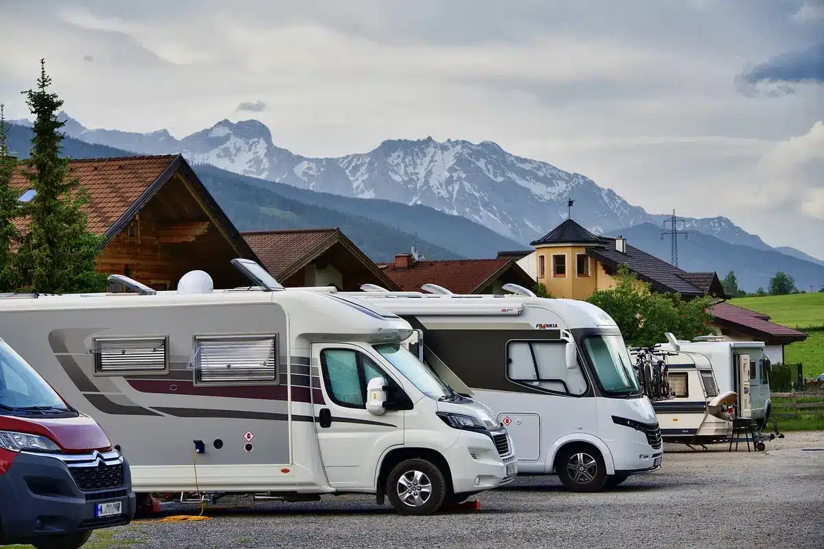 Silhouette devant un petit camping-car aménagé dans un paysage rural, évoquant la vie nomade