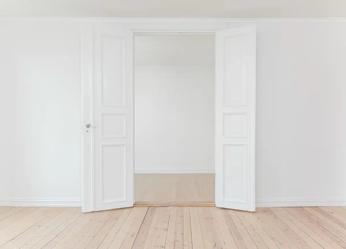 Couloir lumineux avec porte semi-ouverte et gabarit en carton au sol