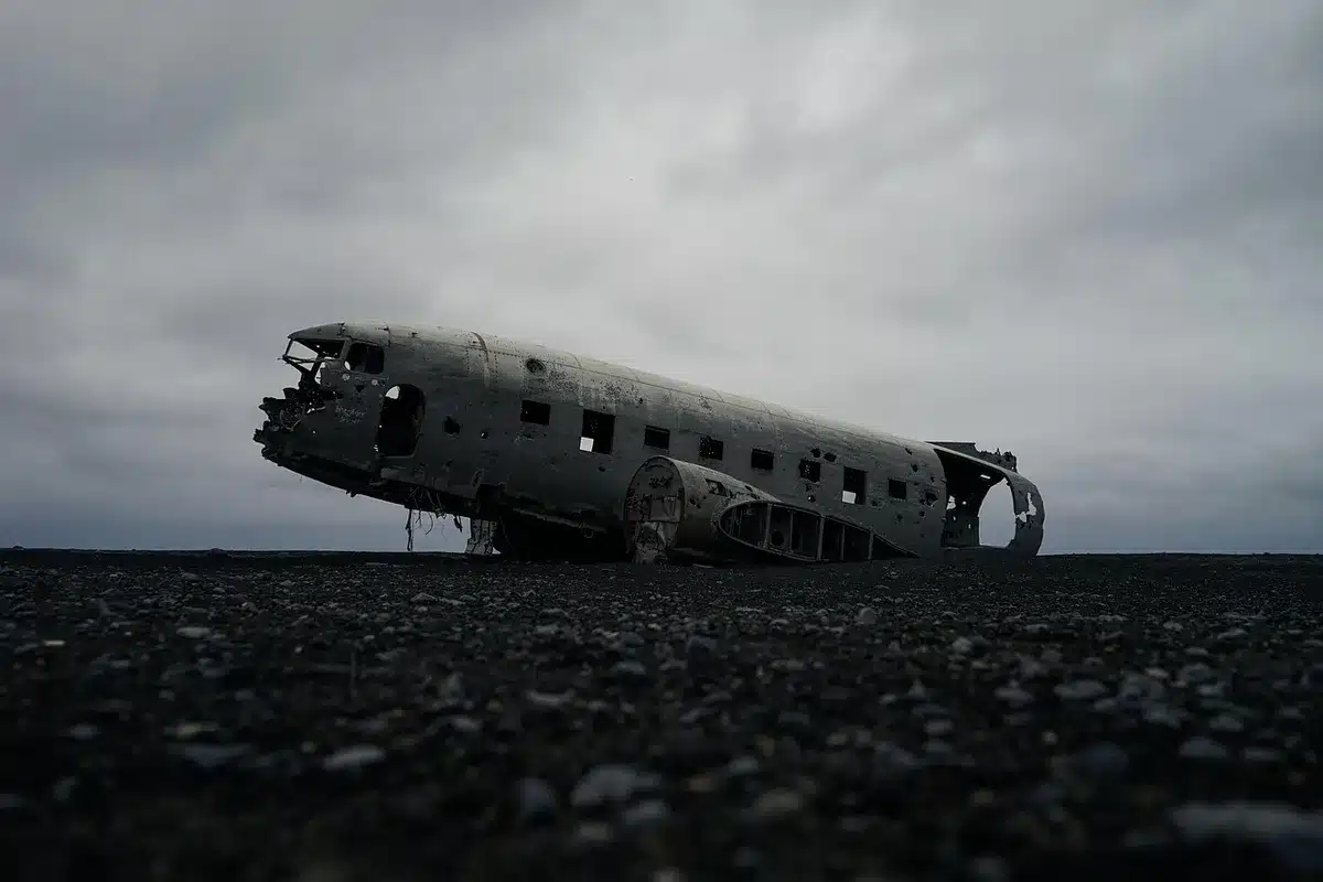 Techniciens anonymes inspectant un panneau de fuselage d'avion dans un hangar en plein jour