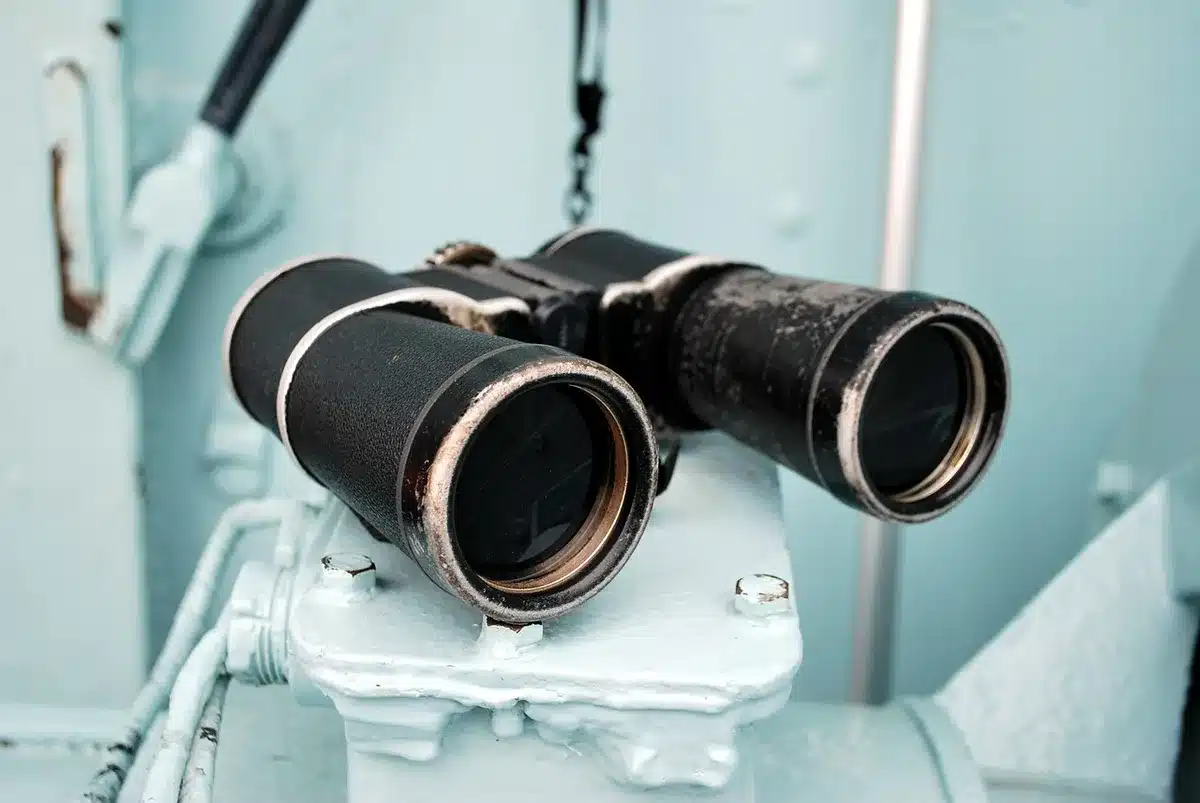 Observateur avec jumelles regardant la Lune depuis un horizon dégagé