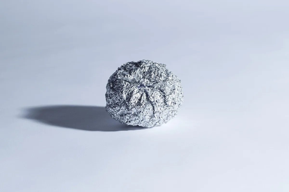 Petit morceau d'aluminium posé à plat dans le panier supérieur d'un lave-vaisselle