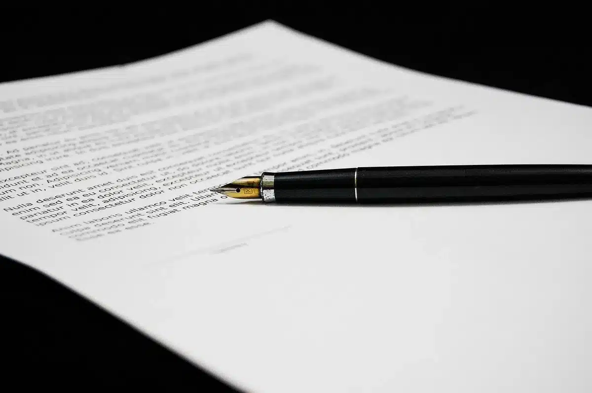 Deux mains feuilletant des documents juridiques relatifs à la filiation