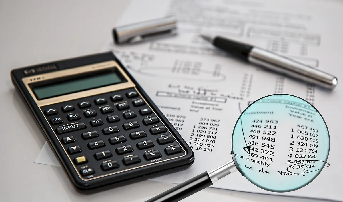 Documents de donation et calculatrice posés sur une table, illustrant l'abattement de 50 000 €