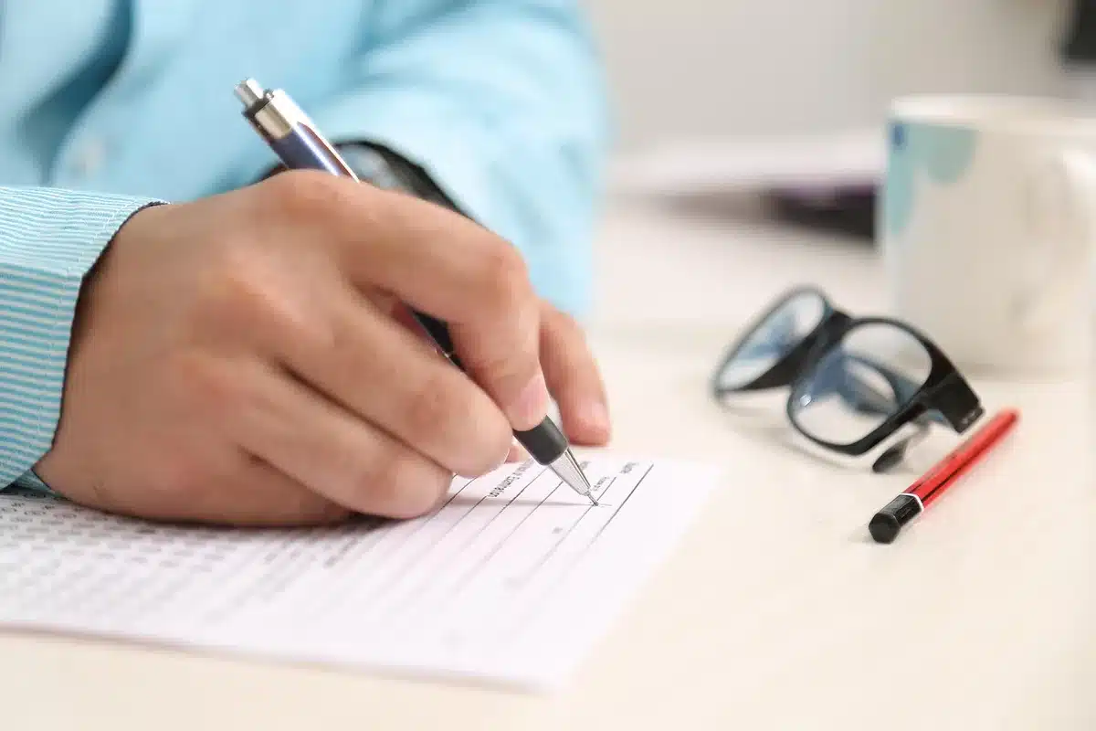 Bureau d'avocat en journée, mains au-dessus de documents et smartphone posé