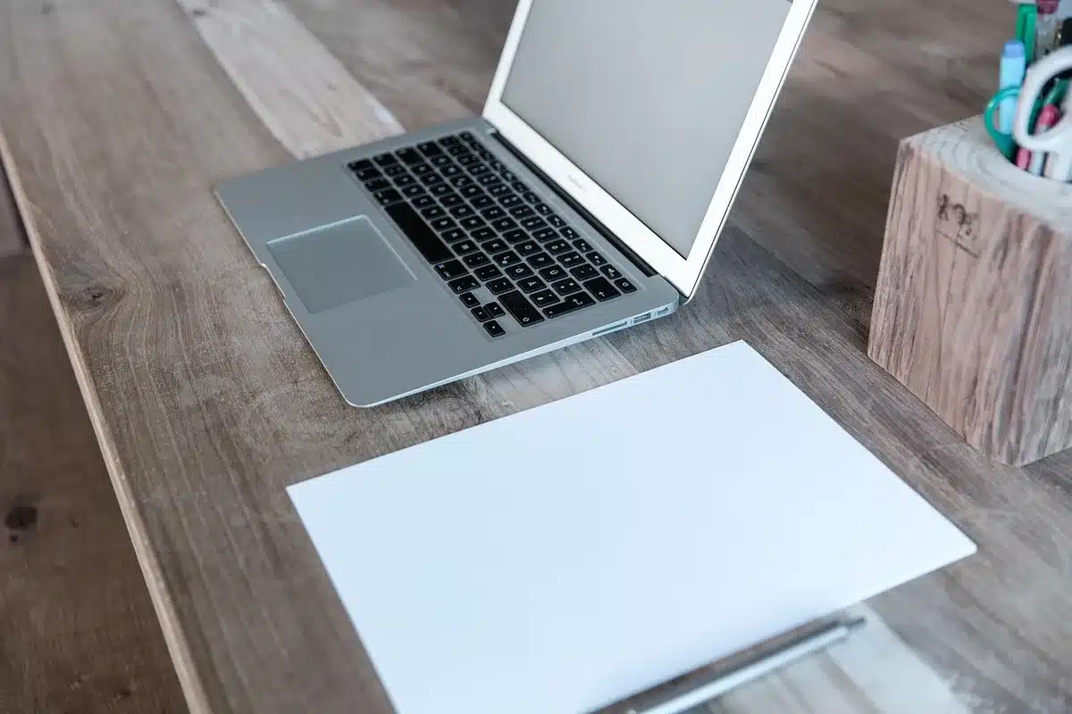 Couple examinant des documents de prêt immobilier à une table éclairée par la fenêtre