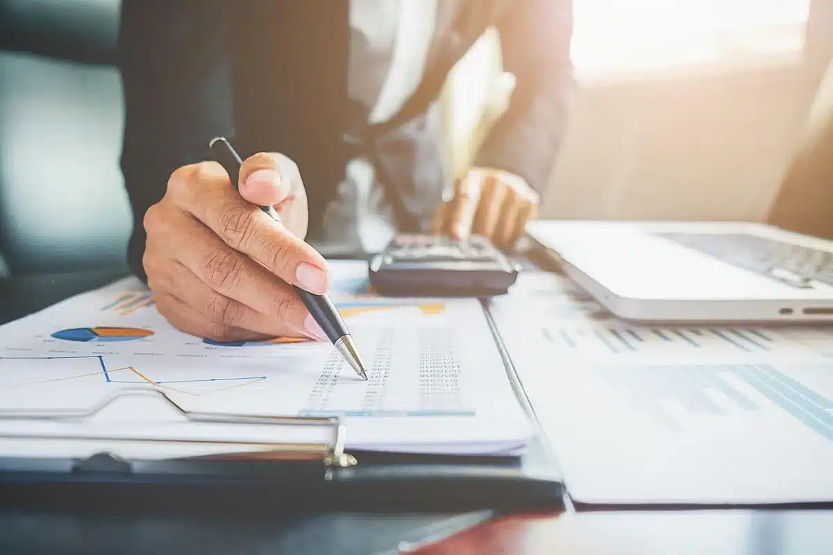 Mains anonymes triant des documents de retraite sur une table en lumière du jour