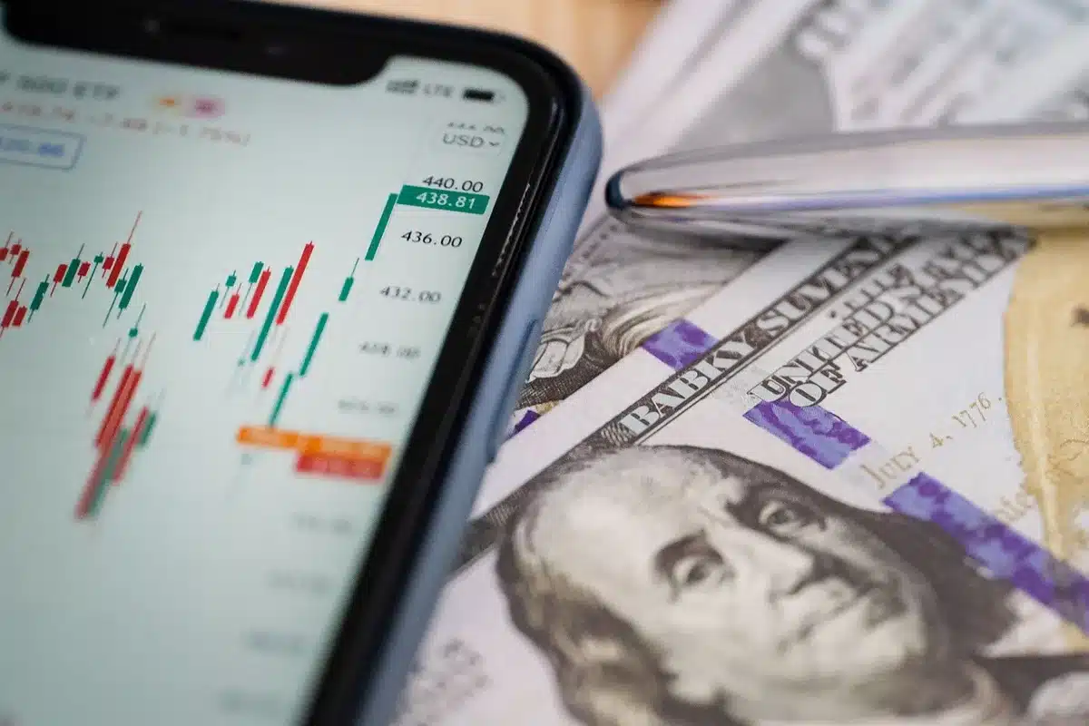 Bureau en journée avec graphiques financiers, calculatrice et mains feuilletant des papiers