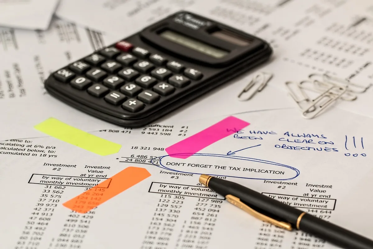 Calculatrice, contrats de prêt et documents financiers sur une table