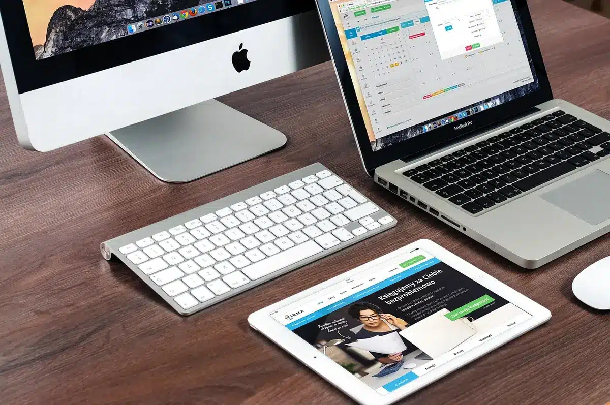 Bureau d'agence lumineux avec dossiers et tablette, mains anonymes feuilletant un contrat