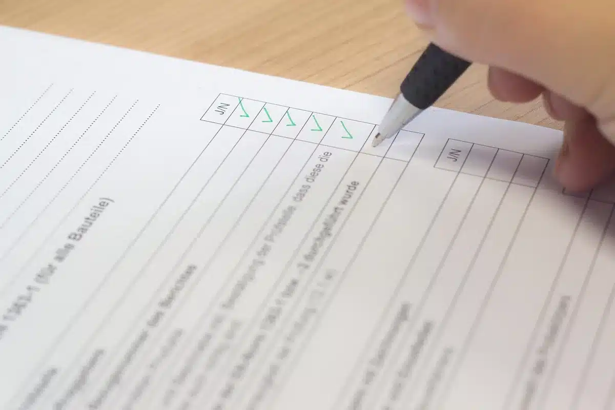 Personne vérifiant une checklist de documents pour un courtier immobilier