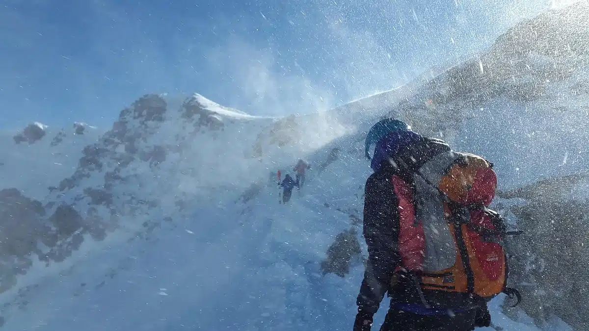 Sac à dos glacière posé sur une table de pique-nique en plein jour avec mains rangeant une bouteille
