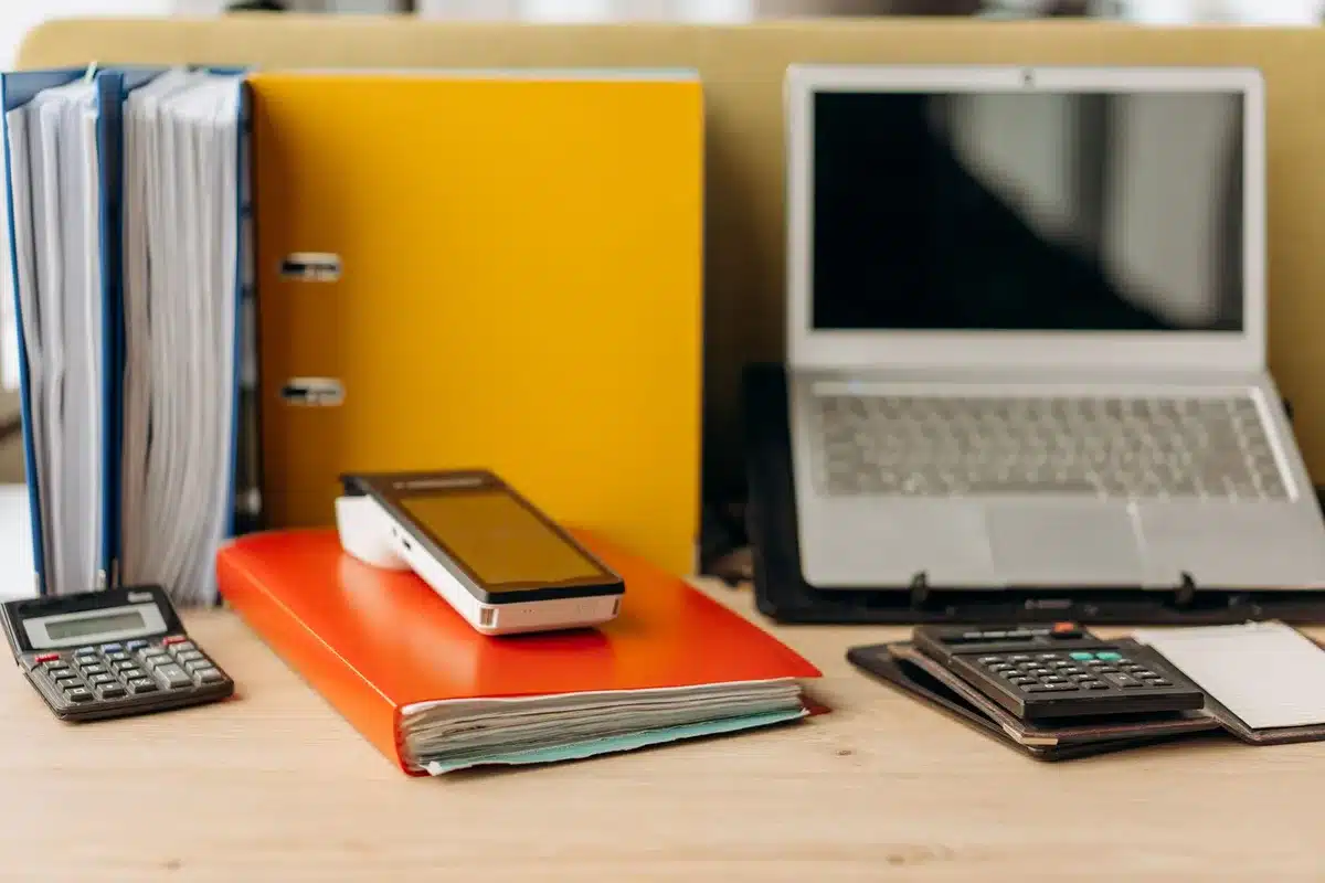 Bureau à domicile lumineux avec documents et calculatrice sur une table près d'une fenêtre