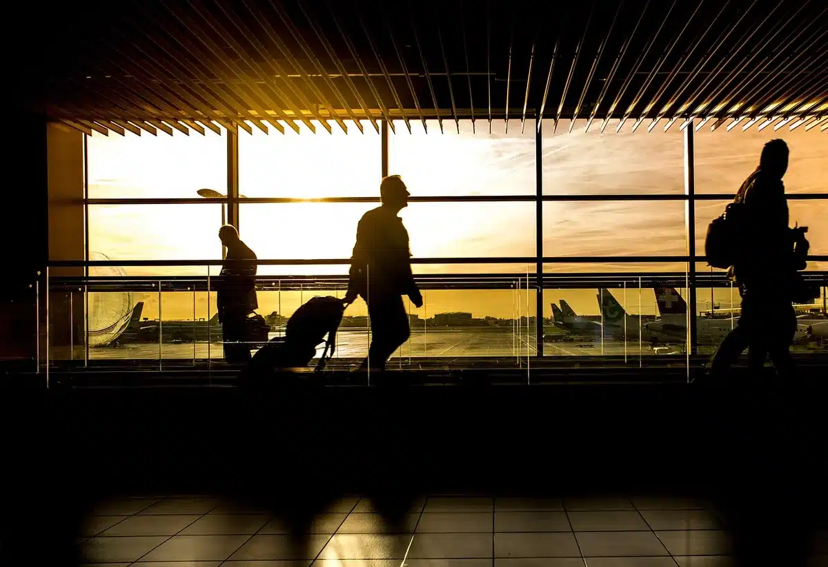 Valise vide et tickets de voyage annulés posés sur un lit
