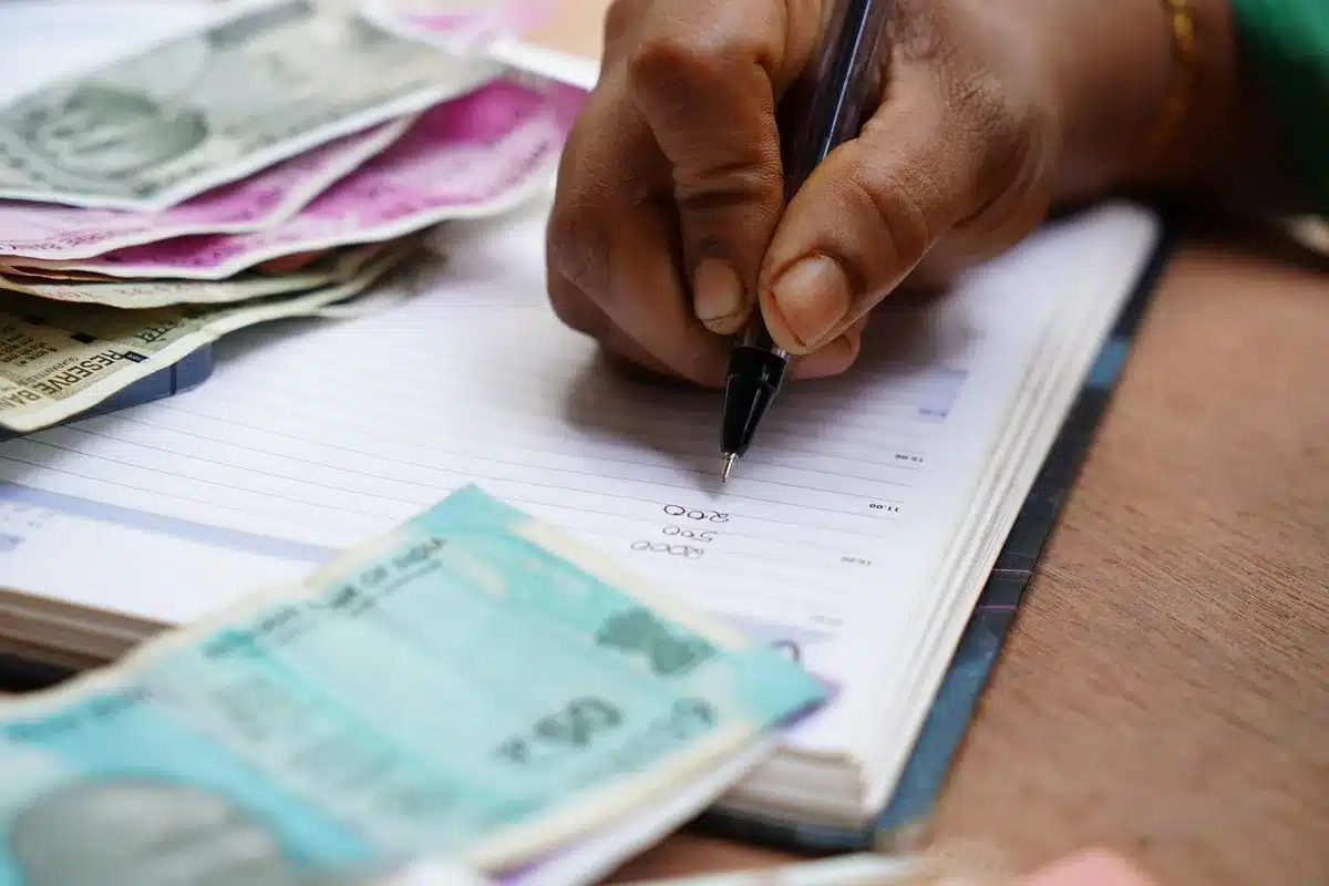 Personne anonymisée vérifiant des documents bancaires et une calculatrice