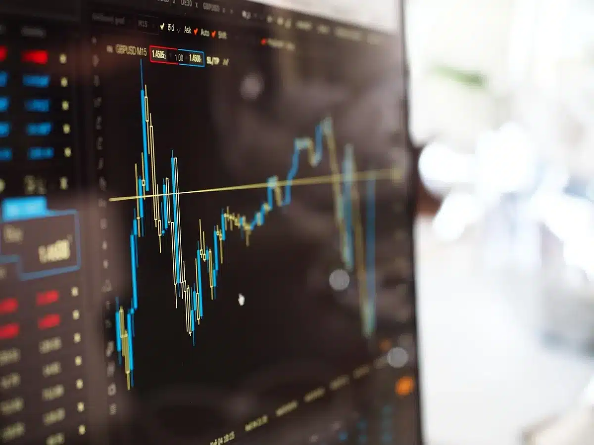 Graphique boursier montrant moyennes mobiles et volumes sur écran