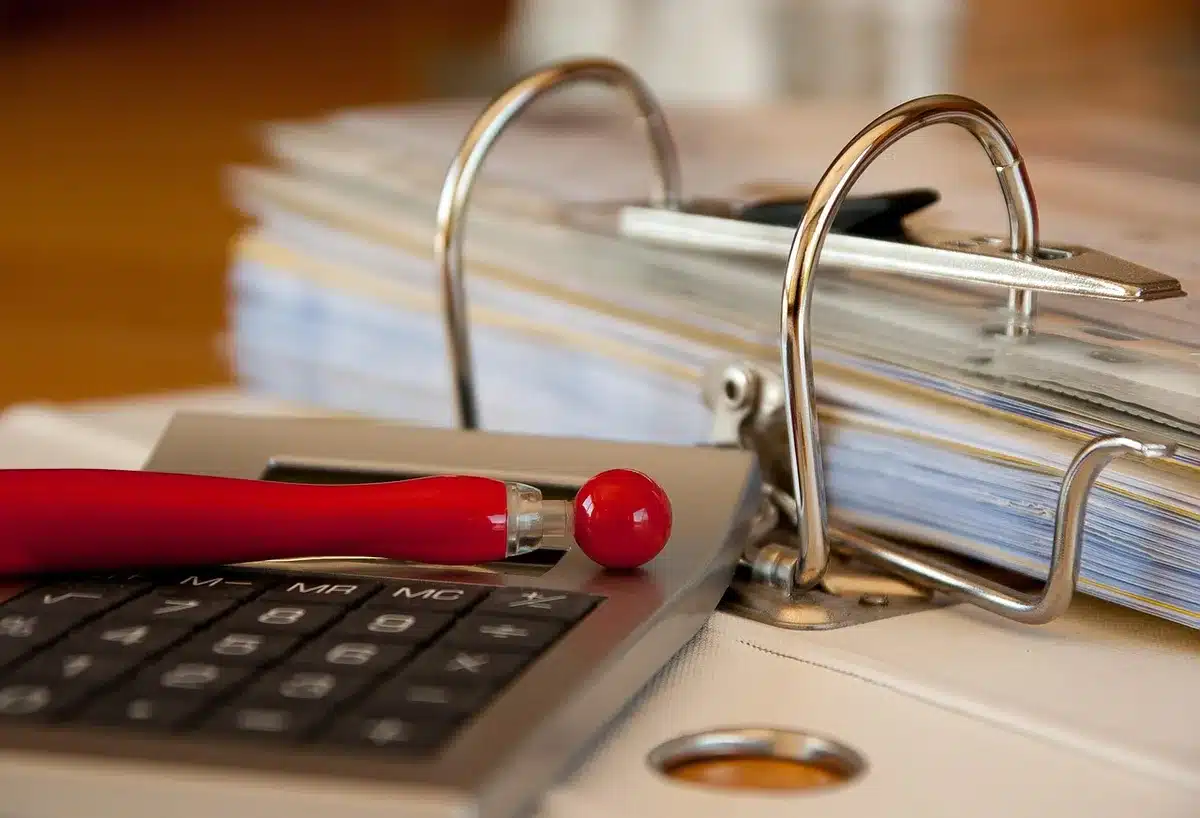 Documents comptables, calculatrice et formulaires fiscaux sur une table de travail