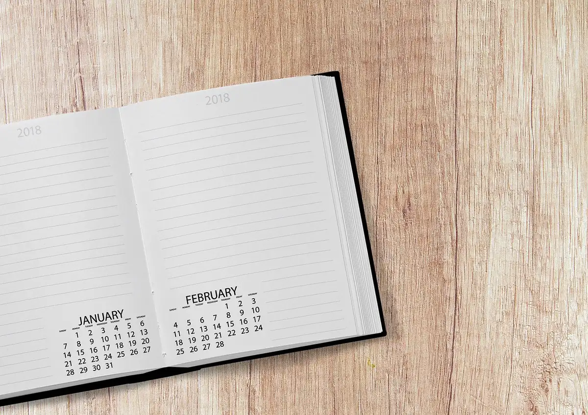 Calendrier et relevé de pension sur un bureau, mains pointant une date