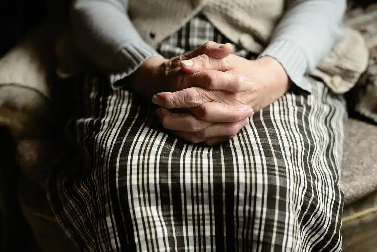 Couple senior anonymisé consultent des papiers de retraite sur une table baignée de lumière