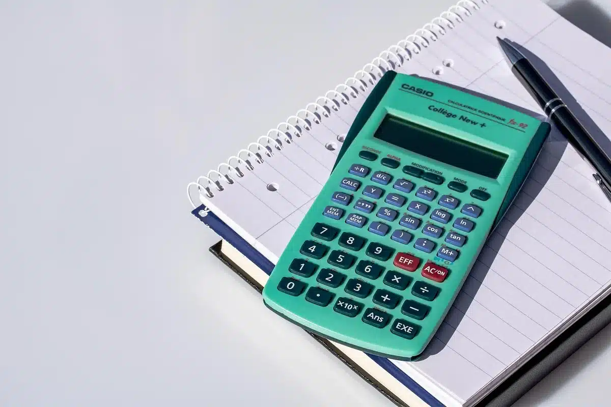 Documents de souscription et calculatrice sur un bureau près d'une fenêtre en plein jour