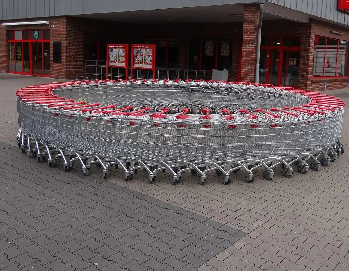 Caisse automatique de supermarché en plein jour avec chariot et mains posant un panier