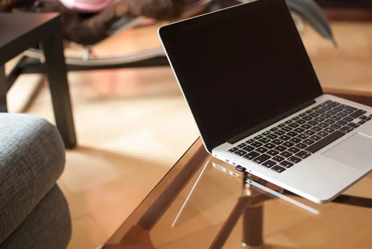 Bureau à domicile en plein jour avec ordinateur en visioconférence et bloc-notes